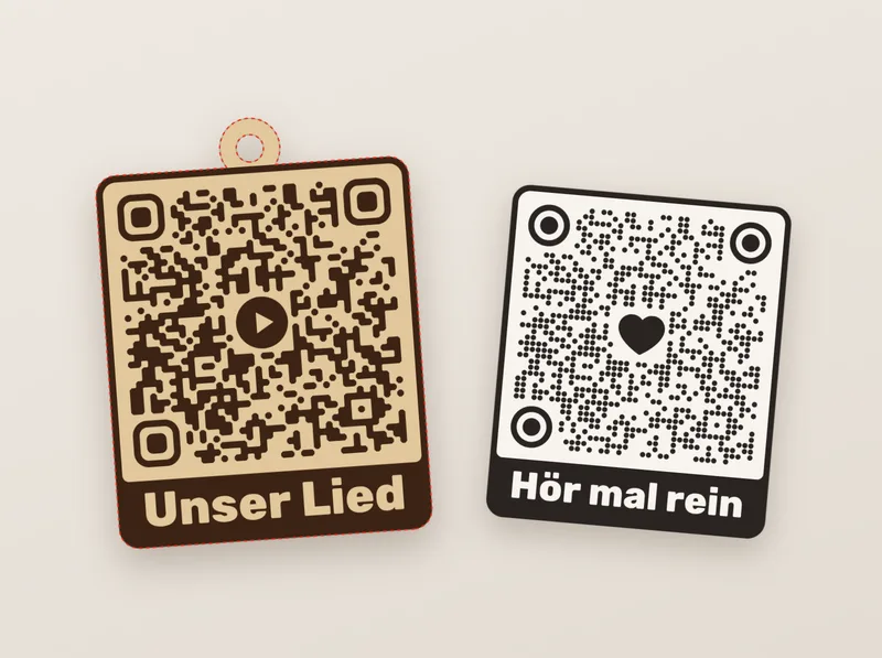 QR-Code mit Play-Knopf in der Mitte und dem Text „Unser Lied“, auf Holz gelasert